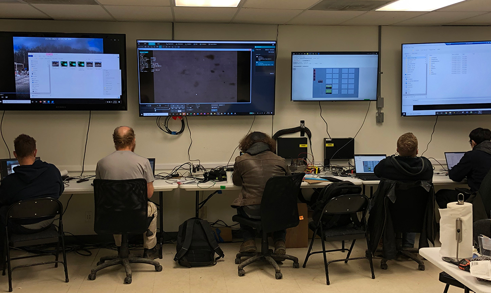 Artis Live Fire Test Range, 5 staff members working indoors looking at large data monitors mounted on wall
